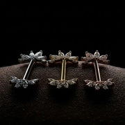 Three pairs of nipple barbells on a dark textured surface with a black background
