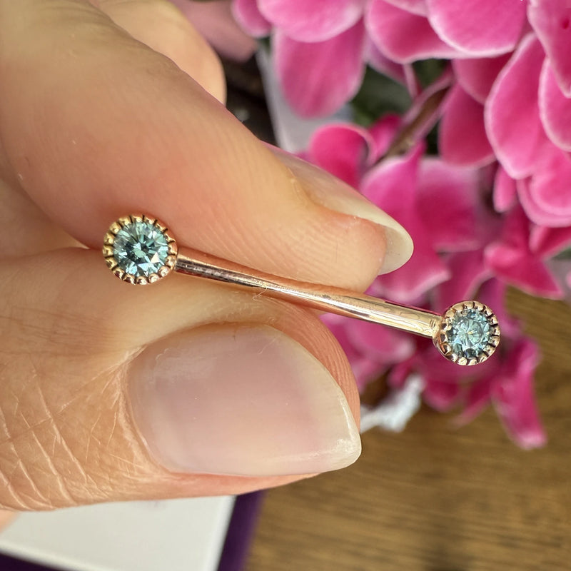 14k rose gold aqua diamond Perlagé nipple barbell held in hand for size reference