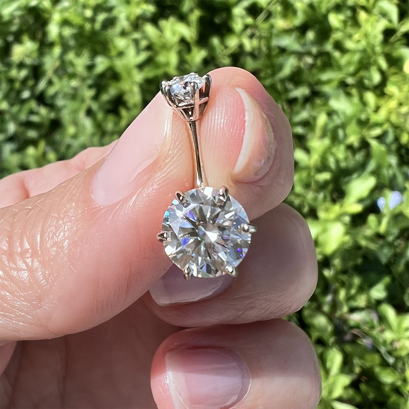 Moissanite Astra II navel ring held between fingers outdoors showing 8mm stone size reference