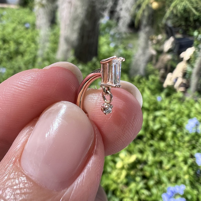 14k rose gold baguette drop floating navel ring held in hand for size reference