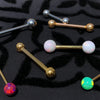 Assorted industrial barbells with opal and plain ball ends in gold and silver tones on black patterned surface