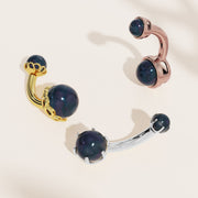 Black Akoya pearl belly rings compared in yellow gold, rose gold, and white gold scroll settings