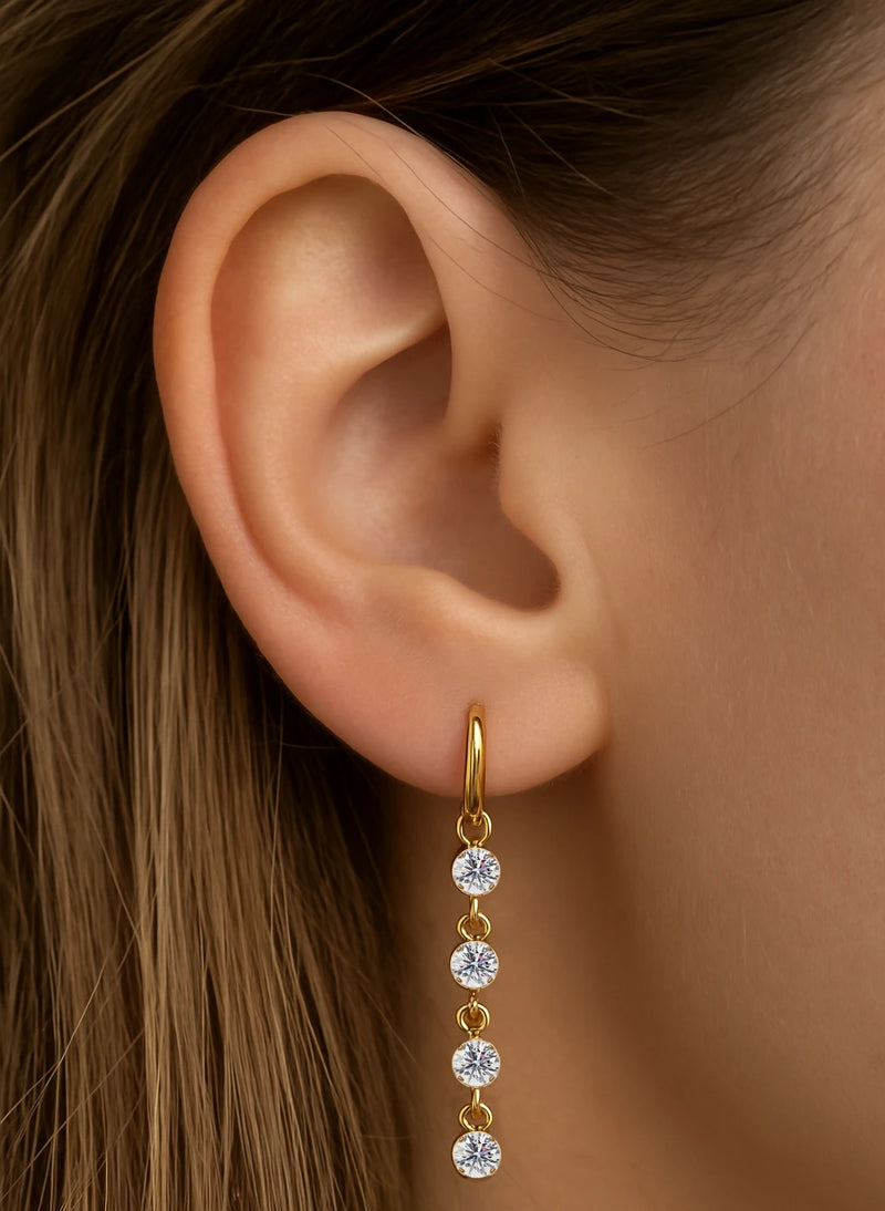 14k yellow gold CZ drop piercing charm worn on a hoop earring, shown on model's ear for fit and scale