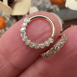 Two 14k yellow gold diamond bubbles seam rings held between fingers for size and scale reference