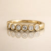 14k yellow gold bubbles seam ring with CZ bubble bezel settings, angled front view on reflective surface