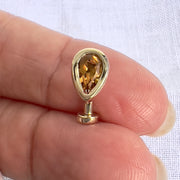 14k yellow gold citrine teardrop floating navel ring held in fingers for size reference