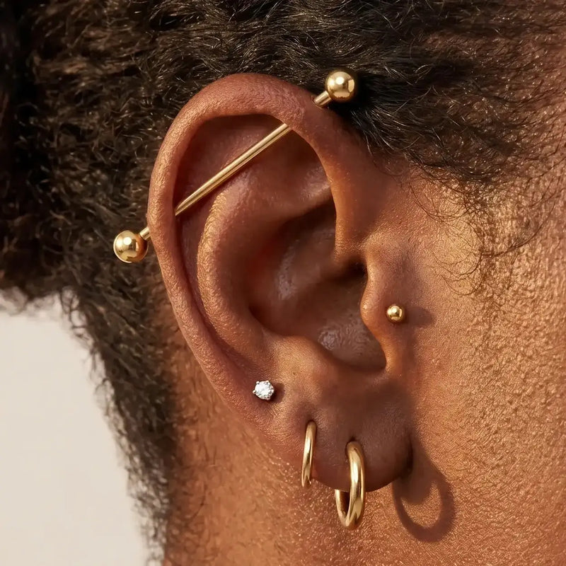 Model wearing a 14K gold Classic Industrial Barbell in an ear industrial piercing, alternate view