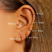 Size guide showing gold clicker hoops from 4mm to 12mm diameter worn across ear piercings on model