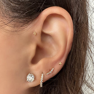 14k gold mini climber earring worn in second lobe piercing, styled with curated ear stack