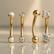14k yellow gold curved barbells with pearl, CZ bezel, plain ball, and prong-set CZ ends compared