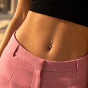 Model wearing a 14k gold prong-set curved barbell with 4mm clear gems in a belly button piercing - shown for size and placement; the amethyst version is the same size