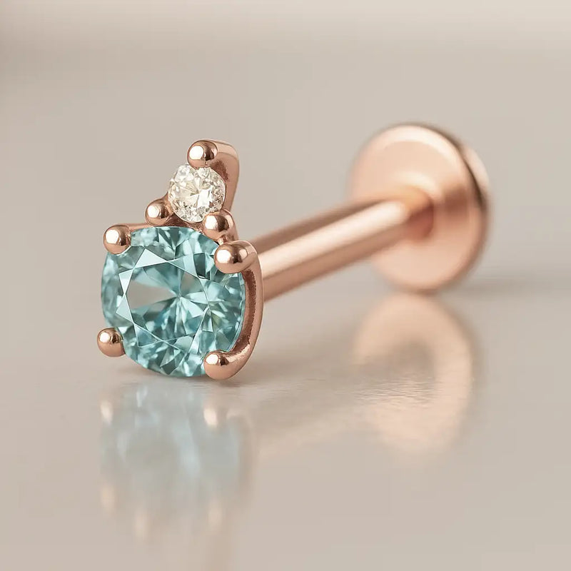 14k rose gold aquamarine and diamond accent flat back labret showing warm gold tone contrast with blue gem