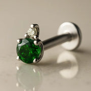 14k white gold emerald and diamond accent flat back labret, angled view showing silver-toned prong setting