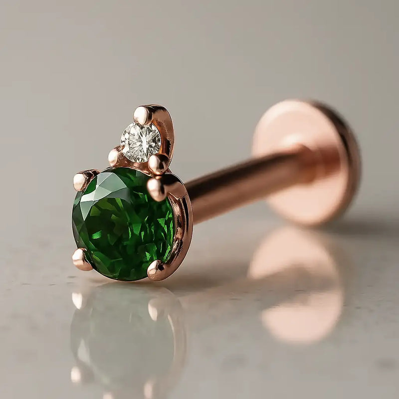 14k rose gold emerald and diamond accent flat back labret, angled view showing warm pink-gold setting