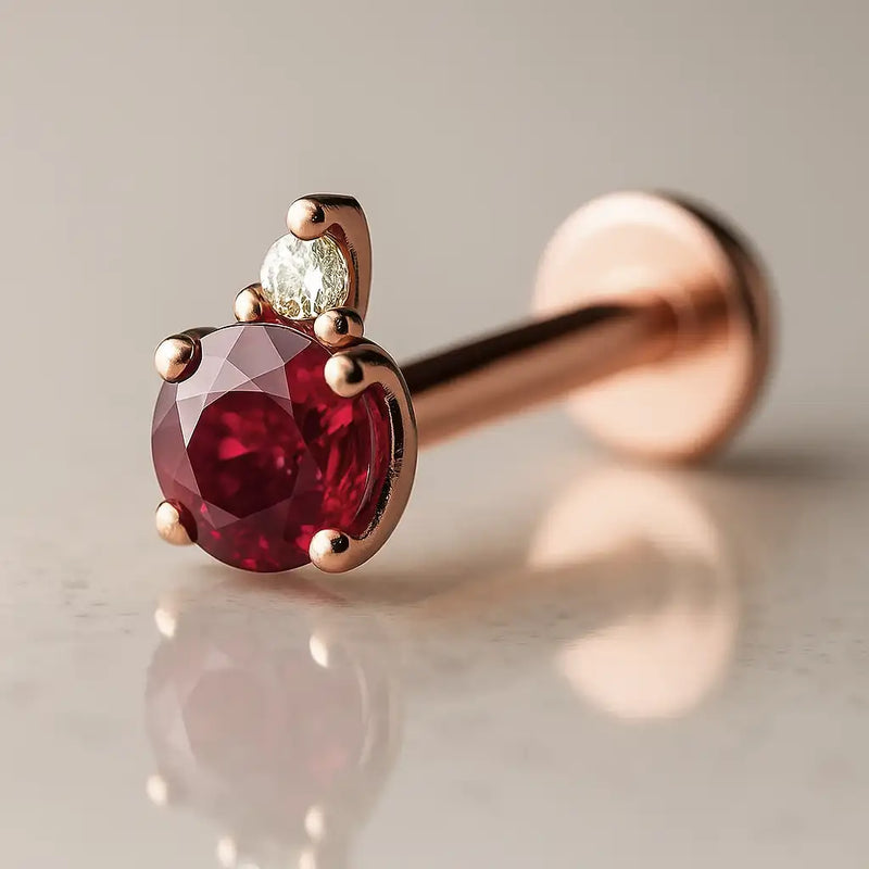 14k rose gold ruby and diamond accent flat back labret, angled view highlighting warm pink-gold setting