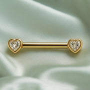 14k yellow gold white sapphire heart nipple barbell resting on draped sage silk fabric, lifestyle shot