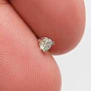 Close-up of 3mm VS1 diamond in 3-prong white gold setting resting on fingertip, showing tiny scale