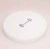 14K white gold marquise fan nipple barbell resting on white ceramic dish, angled view
