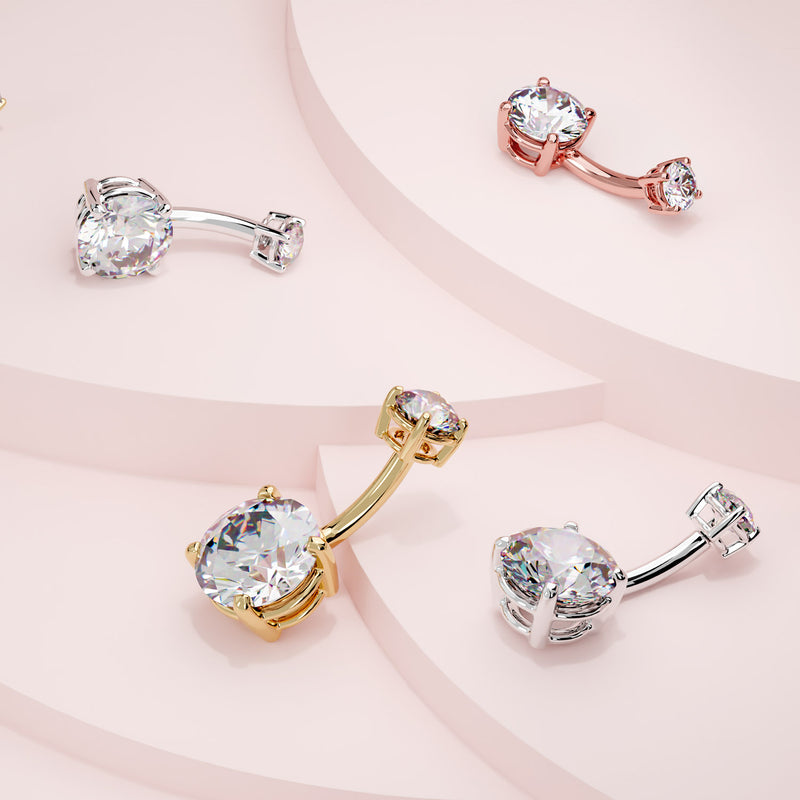 Diamond belly rings in white gold, yellow gold, and rose gold options displayed on pink stepped surface