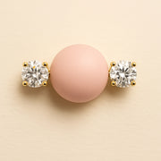 Close-up of 14k yellow gold diamond nipple barbell ends showing four-prong round brilliant diamond settings and scale