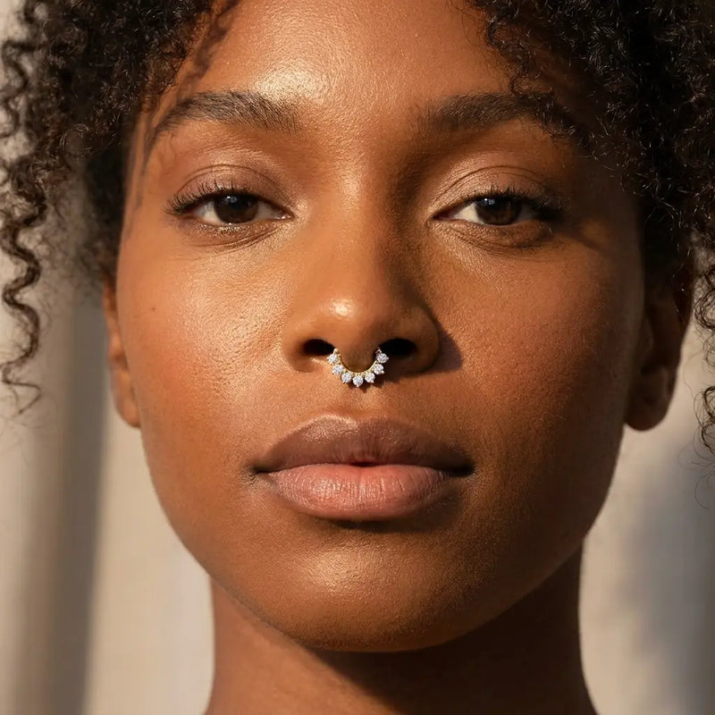 Diamond Petal 14K gold clicker ring worn in a septum piercing on a model, close-up showing the diamond-set petals sitting flush against the skin