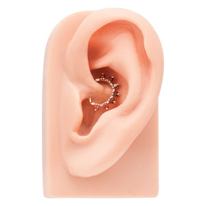 14K rose gold garnet petal clicker ring shown in a daith piercing on ear model