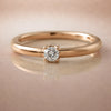 14K rose gold diamond side-set seam ring hoop with prong-set round diamond, on reflective surface