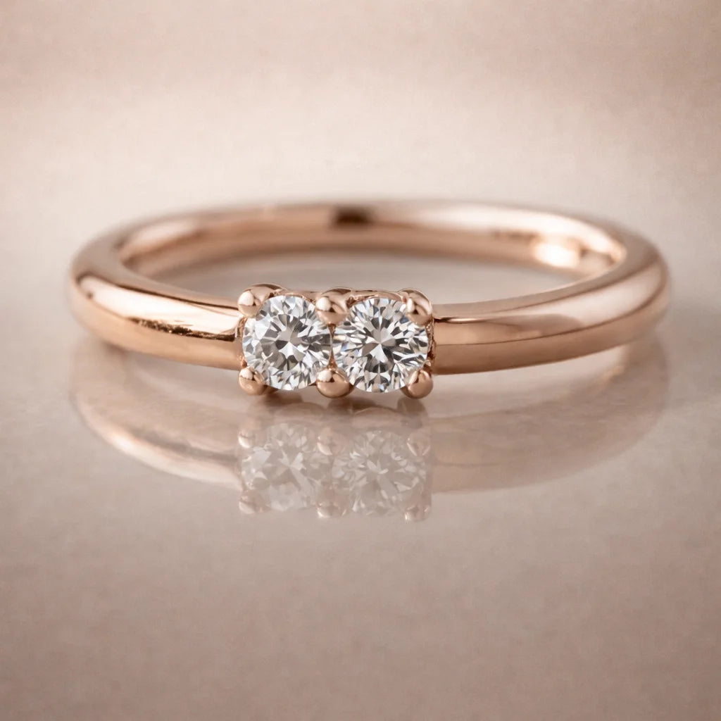 14K rose gold two-diamond seam ring hoop with prong-set VS1 diamonds, front view on reflective surface