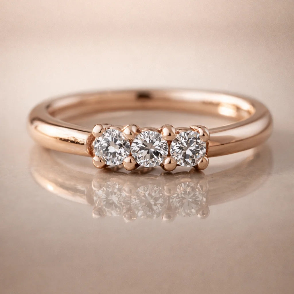 14k rose gold three-diamond seam ring hoop on reflective surface, front view