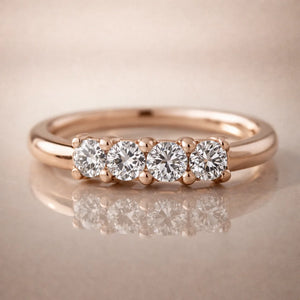 14K rose gold four-diamond side-set seam ring on reflective surface, front studio view