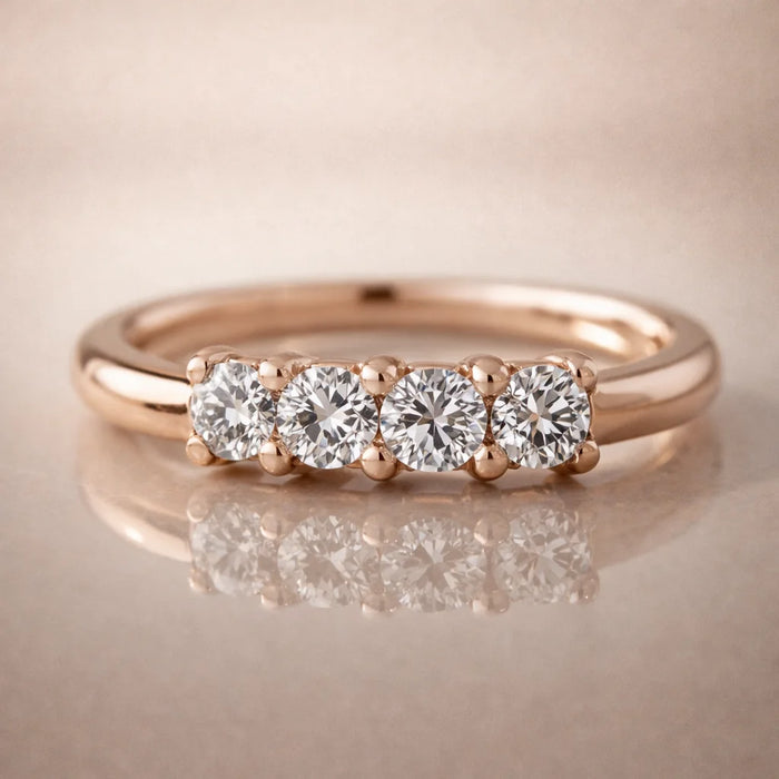 14K rose gold four-diamond side-set seam ring on reflective surface, front studio view