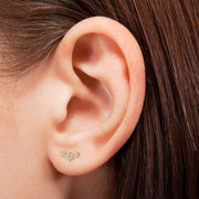 14k yellow gold triple flower earring shown on pierced earlobe, demonstrating fit and size on model