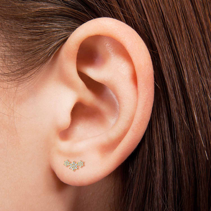 14k yellow gold triple flower earring shown on pierced earlobe, demonstrating fit and size on model