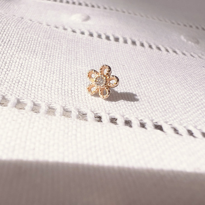 14k yellow gold dainty daisy flower push pin end shown on white linen fabric for size reference