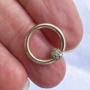 14K yellow gold diamond pavé fixed bead ring held in hand, full hoop and sparkle visible for scale