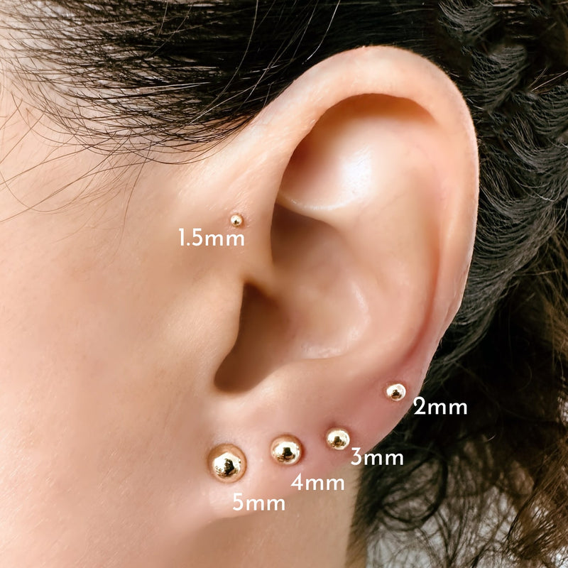 Gold dome flat back studs shown on model's ear comparing 1.5mm, 2mm, 3mm, 4mm, and 5mm sizes