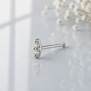 14K white gold double diamond nose bone style, angled view showing ball-end post on gray surface