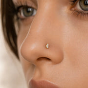 Double diamond 14K gold nose stud worn in nostril piercing, front-facing model close-up