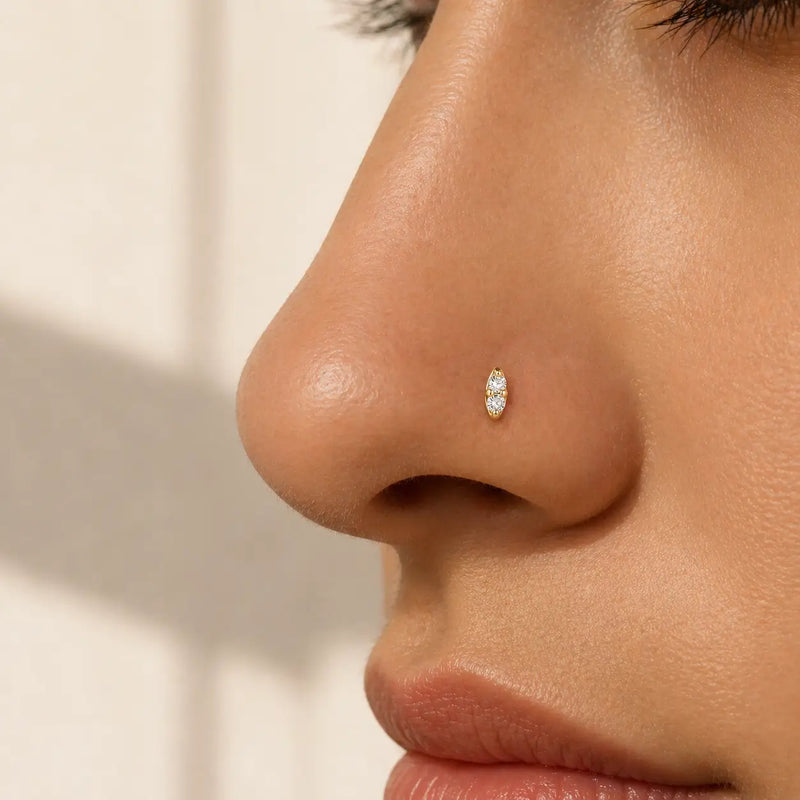 14K yellow gold double diamond nose stud shown in pierced nostril, side profile on model