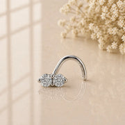 14K white gold double diamond nose ring twist with prong-set diamonds on neutral background