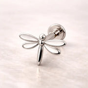 14k white gold dragonfly flat back labret stud with open-wing design, side angle on marble