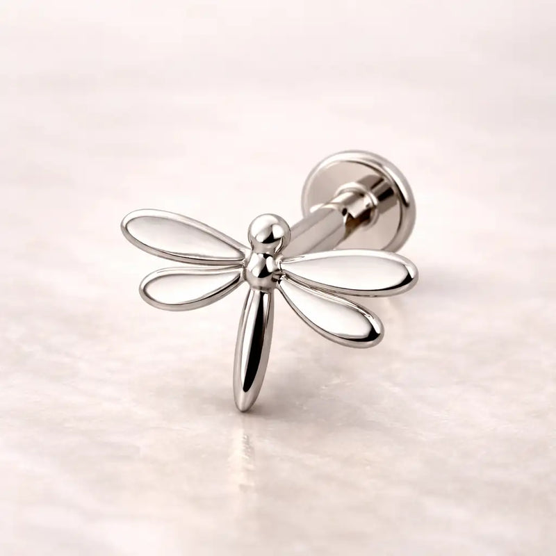 14k white gold dragonfly flat back labret stud with open-wing design, side angle on marble