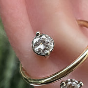 Close-up of VS1 diamond in duo-prong gold setting shown in pierced ear cartilage area