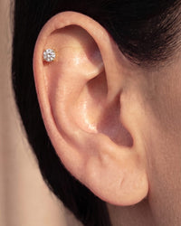 Diamond flat back stud worn in a helix piercing on the upper ear cartilage