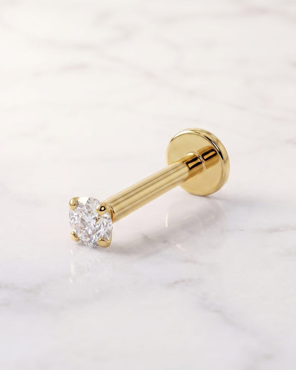 Flat back earrings - 14k yellow gold prong-set diamond flat back stud showing its flat disc back on white marble