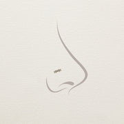 Illustration of 14k gold baguette diamond stud end placement on a nose piercing diagram