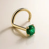14K yellow gold genuine emerald nose ring twist style, angled view showing prong-set green stone