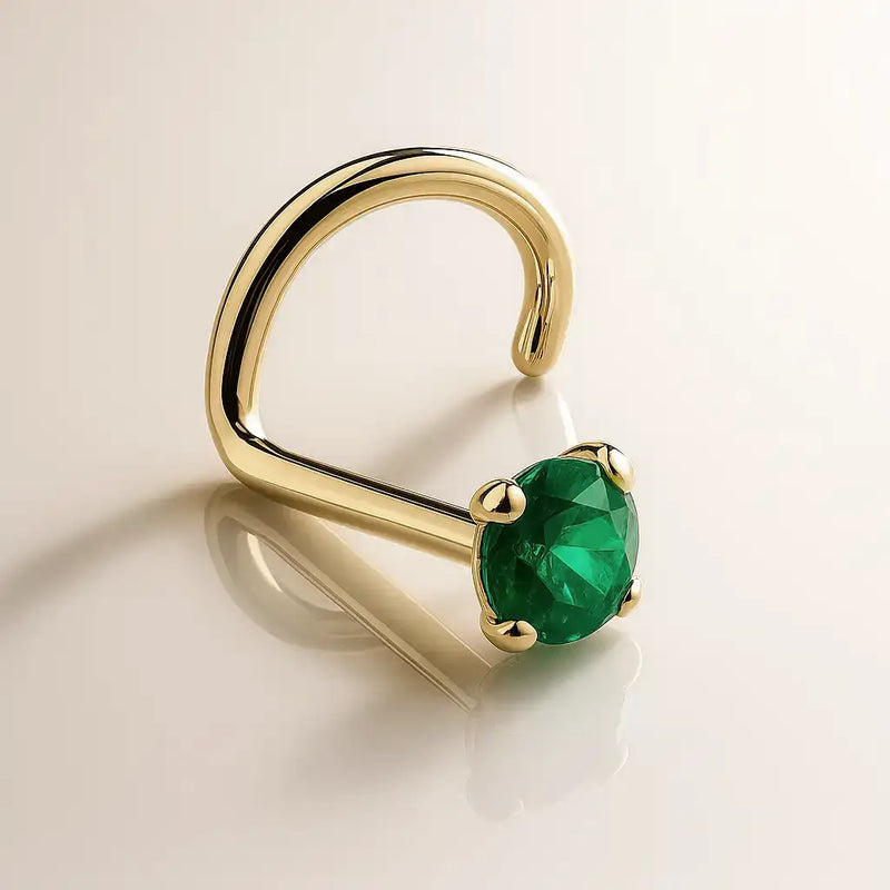 14K yellow gold genuine emerald nose ring twist style, angled view showing prong-set green stone