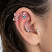 White gold evil eye blue topaz flat back stud in inner conch piercing, styled ear stack on model