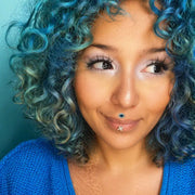 Evil eye diamond blue topaz labret stud worn as lip piercing on model with blue curly hair
